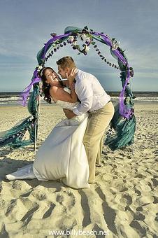 Product: Groom attempting to kiss his new bride at the alter. She is backing away. Ocean Isle Beach, NC - Billy Beach Photography in The Kerridor - Wilmington, NC Photography