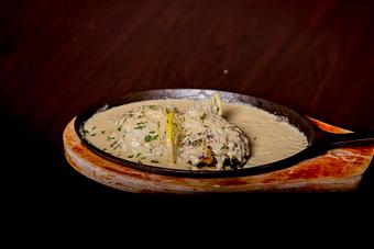 Product: Fresh portobello mushrooms loaded with our signature crab stuffing baked to perfection, topped with a savory Parmesan cheese sauce. - Black Rock Bar & Grill in Orlando, FL American Restaurants