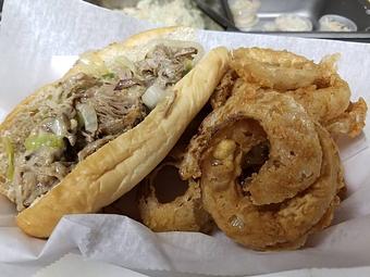 Product: Texas Cheesesteak Sandwich w/onion rings - Blue Ridge BBQ & Catering in Lynchburg, VA Barbecue Restaurants