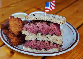 Product: Pastrami meat sandwich served on rye toast and cut in half with the two halves stacked on top of each other - Bub City in Rosemont, IL Barbecue Restaurants