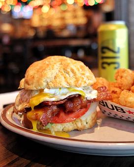 Product: A biscuit sandwich with egg and bacon served with a cardboard boat of tater tots - Bub City in Rosemont, IL Barbecue Restaurants
