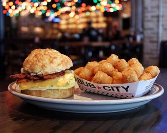 Product: Bacon, egg and cheese sandwich served on a biscuit with a cardboard boat of tater tots - Bub City in Rosemont, IL Barbecue Restaurants