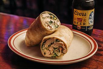 Product: Chicken Caesar wrap cut in half and resting on a white plate - Bub City in Rosemont, IL Barbecue Restaurants