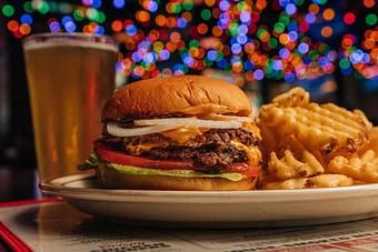 Product: Cheeseburger on a white plate with waffle-style French fries - Bub City in Rosemont, IL Barbecue Restaurants