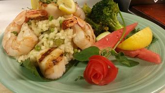 Product: Green herb risotto with grilled shrimp and scallops. - Buffleheads Restaurant At Hills Beach in Biddeford, ME American Restaurants