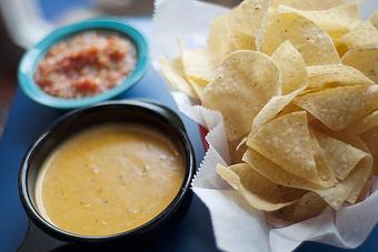 Product: Our chile con queso is a homemade blend of melted cheese, Green Chile sauce and Ranchero sauce - Chuy's in College Station, TX Tex Mex Restaurants