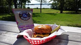 Product: Sounds so wrong, but tastes so right!  Topped with American Cheese, peanut butter & two slices of Nueske's Cherrywood smoked bacon, this burger is surprisingly addictive! - Deerfoot Lodge in Hayward - Hayward, WI American Restaurants