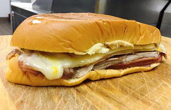 Product: Ham, Swiss Cheese, Pulled Pork, Mustard and Pickles on a soft, sweet egg dough bread - El Brazo Fuerte Bakery in Pembroke Pines, FL Bakeries