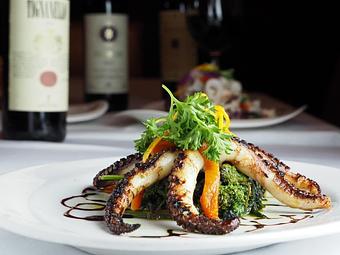 Product: tender baby octopus appetizer served over sauteed spinach - Empire Steak House in New York, NY Seafood Restaurants