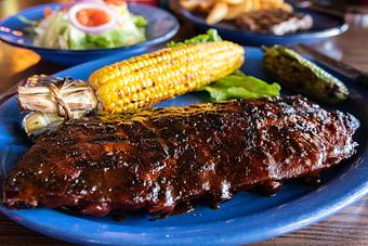 Product: Dr Pepper BBQ ribs with roasted corn on the cob. Duroc pork. - Hoffbrau Steak & Grill House in Granbury, TX American Restaurants