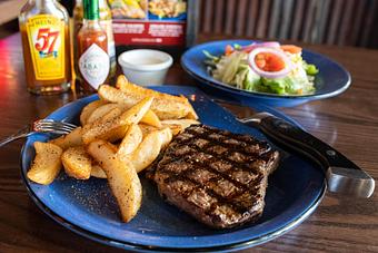 Product: Strip Steak served with fries - Hoffbrau Steak & Grill House in Granbury, TX American Restaurants