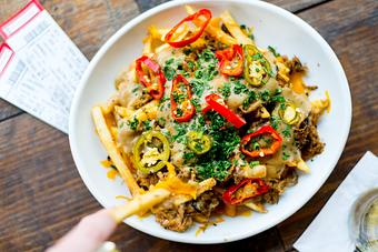 Product: Extra-crispy fries topped with pulled pork, pickled jalapeños, melted cheese, and brown gravy - House of Blues Restaurant & Bar in Anaheim, CA Restaurants/Food & Dining