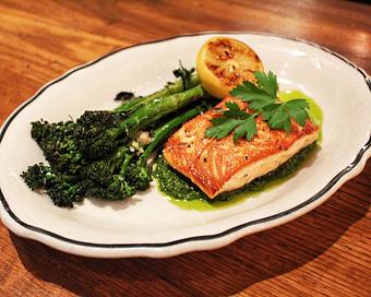 Product: fresh faroe island salmon is simply broiled and sits on top of a caper lemon pesto sauce. served with garlic roasted broccolini, and garnished with a charred lemon - Il Porcellino in River North - Chicago, IL Italian Restaurants