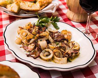 Product: rhode island calamari marinated in fresh garlic and herbs and grilled until tender. served with charred lemon, olive oil and lemon - Il Porcellino in River North - Chicago, IL Italian Restaurants
