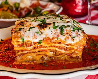 Product: world famous lasagna layered with prime-beef bolognese, fontina, and asiago cream. topped with melted burrata cheese, and served on top of homemade marinara - Il Porcellino in River North - Chicago, IL Italian Restaurants
