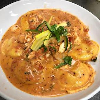 Product: Carbonara Ravioli di Pesce - Seafood ravioli with shrimp, fresh spinach and sundries tomatoes in a garlic, pancetta, cheese cream sauce - La Trattoria Oceanside in Key West Airport - Key West, FL Italian Restaurants