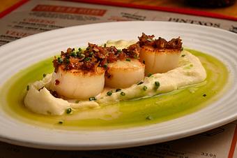 Product: White round scallops resting on a white puree with a green sauce underneath, on an oval white plate - Lil’ Ba-Ba-Reeba! in River North - Chicago, IL Bars & Grills