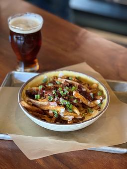 Product: Belgian-style frites, Nueske’s bacon, cheese sauce, green onion, crema - Longtable Beer Cafe in Downtown Middleton - Middleton, WI American Restaurants
