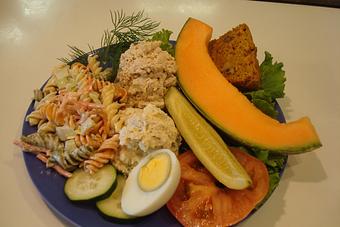 Product: Tuna, Chicken, and Pasta Salad, Hard-Boiled Egg, Tomato, Fruit and a Pickle. Served with apple or pumpkin bread (available seasonally) - Nutshell Eatery & Bakery in Granbury, TX American Restaurants