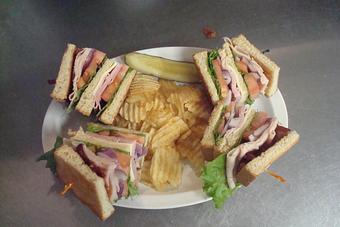 Product: Ham, turkey, bacon & Swiss Cheese with Lettuce, Tomato, and Onion. Served with Chips and a Pickle. - Nutshell Eatery & Bakery in Granbury, TX American Restaurants