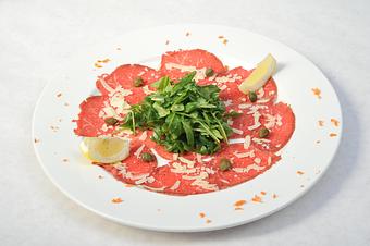 Product: Thin sliced raw filet served with capers, arugula and parmesan cheese drizzled with truffle oil - Pasta D'arte Trattoria Italiana in Chicago, IL Italian Restaurants