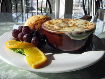 Product: French Onion Soup, a house specialty, shown w fruit and muffin. - Pine Tree Barn in Wooster, OH American Restaurants
