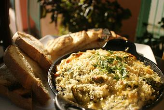 Product: A comforting mix of artichoke hearts, spinach, leeks added to goat, cream and fontina cheeses topped with poblano chilis and panko. Served with grilled breads. - PUBlic 74 in San Juan Capistrano, CA American Restaurants