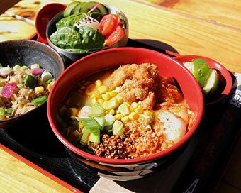 Product: a crunchy and spicy ramen with pork broth, tokyo wavy noodles, green onion, spicy kimchi, karaage fried chicken, buttered corn, fried garlic and housemade sesame chili oil - RAMEN-SAN Whisky Bar in Fulton Market - Chicago, IL Japanese Restaurants