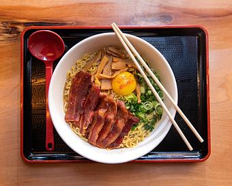 Product: a play on bacon and eggs, this bowl features our 10-hr tonkotsu broth with a sweet soy tare, topped with japanese style crispy bacon, menma, scallions, and a rayu marinated egg yolk - RAMEN-SAN Whisky Bar in Fulton Market - Chicago, IL Japanese Restaurants
