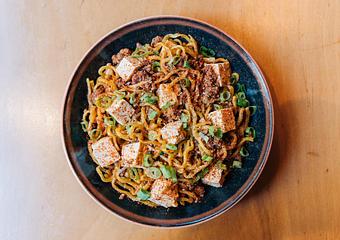 Product: a brothless noodle dish, tossed in a spicy pork & fermented black bean sauce with tofu and topped with ichimi - RAMEN-SAN Whisky Bar in Fulton Market - Chicago, IL Japanese Restaurants