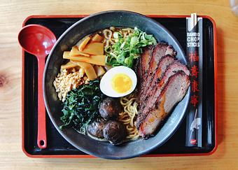 Product: our classic chicken broth with a savory black garlic butter miso, served with tokyo wavy noodles and topped with bub city's 18-hr smoked brisket, braised cremini mushrooms, menma, wakame, molten egg, scallions, fried garlic and rayu - RAMEN-SAN Whisky Bar in Fulton Market - Chicago, IL Japanese Restaurants