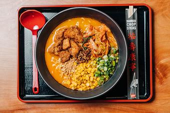 Product: a crunchy and spicy ramen with pork broth, tokyo wavy noodles, green onion, spicy kimchi, karaage fried chicken, buttered corn, fried garlic and housemade sesame chili oil - RAMEN-SAN Whisky Bar in Fulton Market - Chicago, IL Japanese Restaurants