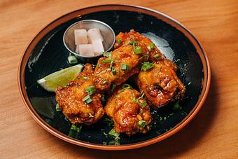 Product: five crispy chicken wings are tossed in a housemade sweet chili sauce. served with pickled japanese daikon radish and lime - RAMEN-SAN Whisky Bar in Fulton Market - Chicago, IL Japanese Restaurants
