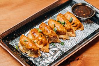 Product: six dumplings are filled with chicken and cabbage and fried crispy. served with a garlic chili soy sauce - RAMEN-SAN Whisky Bar in Fulton Market - Chicago, IL Japanese Restaurants