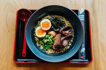 Product: from our collaboration with Soul & Smoke, this ramen features tender smoked brisket, braised collard greens, creole butter, scallion, and a marinated egg - RAMEN-SAN Whisky Bar in Fulton Market - Chicago, IL Japanese Restaurants