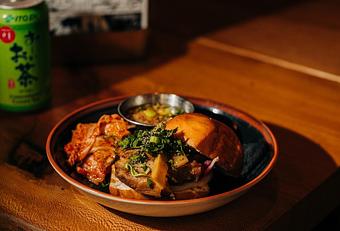 Product: tender pork belly braised in oyster sauce and garlic served on a fried mantou bun with shiitakes, marinated bamboo shoots, pickled daikon, red onions, herb mix, and freshly ground black pepper. served with a side of kimchi, and pork jus. - RAMEN-SAN Whisky Bar in Fulton Market - Chicago, IL Japanese Restaurants