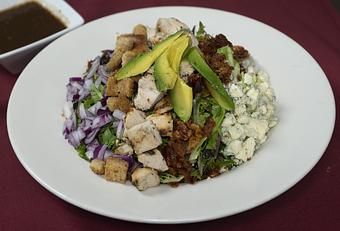 Product: Mixed greens, chicken breast, avocado, hard-boiled egg, crispy bacon, 
bleu cheese, red onion, and croutons with dressing of choice - Remington's at the Montrose Bridges in Montrose, CO American Restaurants