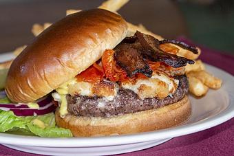 Product: The Beast Burger is available only at Remington's. It is a third-pound beef patty cooked to order, with cheese, lettuce, tomato, and onion on a toasted Brioche bun - Remington's at the Montrose Bridges in Montrose, CO American Restaurants