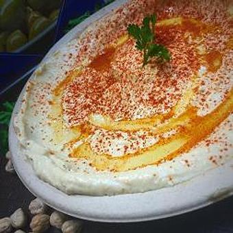 Product: Eight oz cup garbanzo beans pureed with tahini, lemon juice, spices, a touch of olive oil, served with two pitas - Rosemary Grill in Los Angeles, CA Mediterranean Restaurants