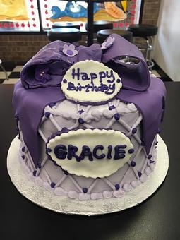 Product: Precious purple buttercream cake with fondant bow and straps - Saweet Cupcakes in San Antonio, TX Dessert Restaurants