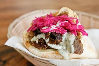 Product: juicy chicken thighs marinated in our shawarma spices, grilled to perfection and served in our fresh-baked pita with salads. - Shaloha in Honolulu, HI Mediterranean Restaurants