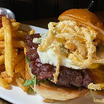 Product: 3/4 pound butter burger, blue cheese crumbles, four
strips crispy bacon, onion strings, cheddar, arugula,
fried egg, special sauce, brioche - SKYBOKX 109 Sports Bar & Grill in Across from the Natick Mall - Natick, MA American Restaurants