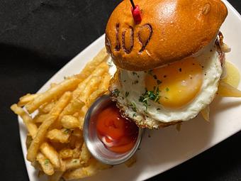 Product: half pound beef burger, brie, sunny side egg,
caramelized onions, truffle aioli, brioche - SKYBOKX 109 Sports Bar & Grill in Across from the Natick Mall - Natick, MA American Restaurants