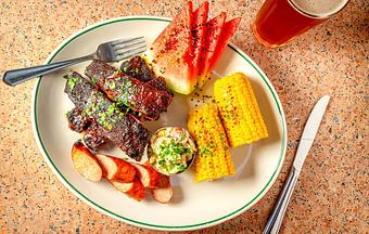 Product: Glazed ribs, garlic sausage, corn on the cob, potato salad, fresh watermelon - Soho Diner in SoHo, NY - New York, NY Diner Restaurants