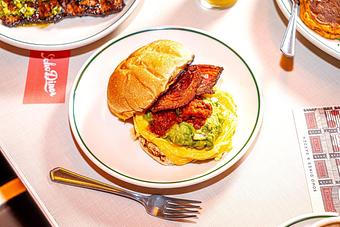 Product: Crisp pancetta, scrambled eggs, American cheese, roasted tomato relish, and crushed avocado served on a potato roll - Soho Diner in SoHo, NY - New York, NY Diner Restaurants