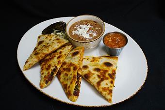 Product: Chorizo Green Chili Quesadilla
Spanish chorizo, roasted poblano chilies, queso fresco, manchego, and cheddar 
cheese, cabbage escabeche, corn salsa, chili toreado and frijoles charros - Stables Ranch Grille - Restaurant-Reservations in Tubac, AZ American Restaurants