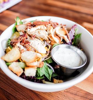Product: Fresh mixed greens, tomatoes, cucumbers, onions, cheddar cheese, bacon bits and croutons topped with flame-broiled marinated chicken breast - Station 16 in Sacramento, CA Bars & Grills
