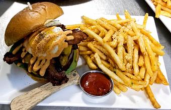 Product: Bacon, cheddar cheese, bacon jam, tomato, lettuce, onion, pickles and fried egg on a brioche bun - Station 16 in Sacramento, CA Bars & Grills