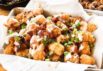 Product: Cheesy Tots (Cheddar cheese, bacon, spicy aioli and sour cream) - Station 16 in Sacramento, CA Bars & Grills