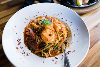Product: Prawns, sausage, tomato garlic cream sauce, spinach and parmesan garnished with chili flakes - Station 16 in Sacramento, CA Bars & Grills